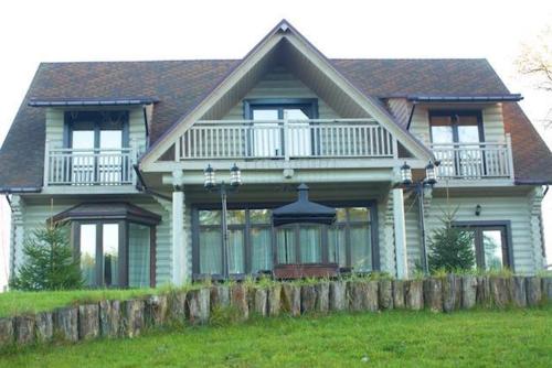 a large house with a fence in front of it at Pastoral wooden hauses in Velikiy Les