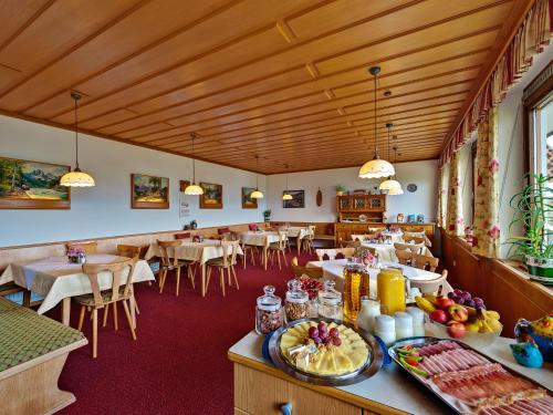 ein Esszimmer mit Tischen, Stühlen und einem Tisch in der Unterkunft Frühstückspension Götzfried-Hof in Millstatt