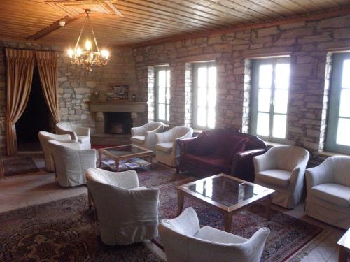 a large living room with white chairs and a fireplace at Casa Mare in Nimfaíon