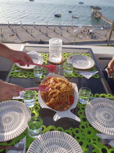 a table with plates of food on a table near the beach at Paracas Penthouse first line Boardwalk in Paracas