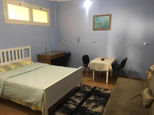 - une chambre avec un lit et une table avec des chaises dans l'établissement A studio / private room in New Cairo, au Caire