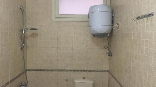 La salle de bains est pourvue de toilettes, d'une fenêtre et d'une douche. dans l'établissement A studio / private room in New Cairo, au Caire