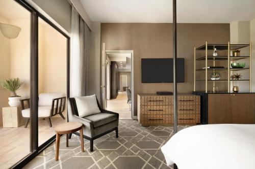 a bedroom with a bed and a chair and a television at Fairmont Scottsdale Princess in Scottsdale