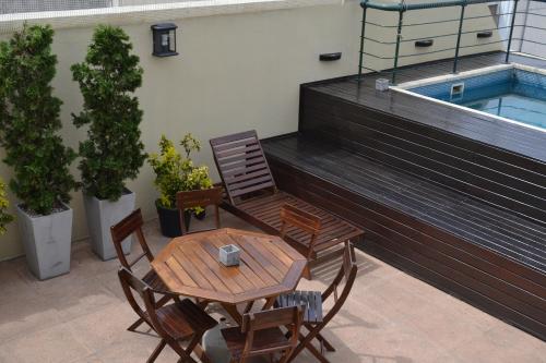 Un patio con mesa y sillas y una piscina. en Piccaluga Apartments, en Buenos Aires