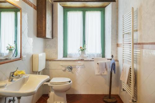 a bathroom with a toilet and a sink and windows at Resort con vista nel Chianti Rufina in Londa