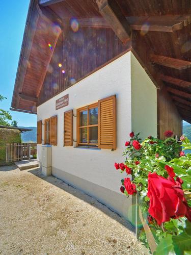 a building with red flowers in front of it at Frühstückspension Götzfried-Hof in Millstatt