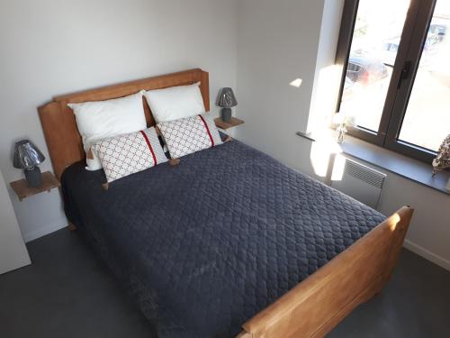 a bedroom with a large bed with pillows and a window at Gîte Au Cœur de Cassel in Cassel