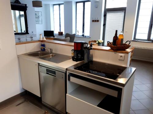 a kitchen with a stove top oven next to a sink at Gîte Au Cœur de Cassel in Cassel