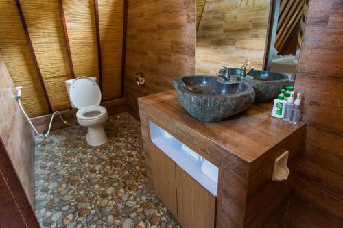 a bathroom with two sinks and a toilet at Batan Sabo Cottage in Nusa Penida