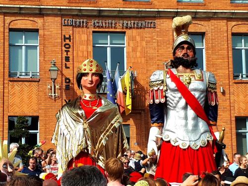 a man and woman dressed in costumes standing in a crowd at Gîte Au Cœur de Cassel in Cassel