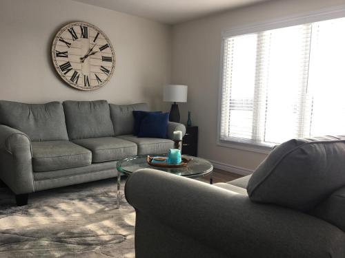a living room with a couch and a clock on the wall at Hammer Haus II in Waterloo