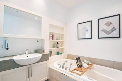 a bathroom with a white tub and a sink at La Villa du Notaire in Lévis