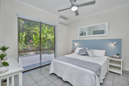 a bedroom with a bed and a large window at Cairns Northern Beaches Holiday Retreat in Clifton Beach