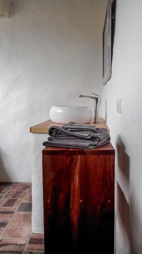 a bathroom with a sink on top of a wooden table at El Paraiso - B&B Finca San Vicente in Barichara