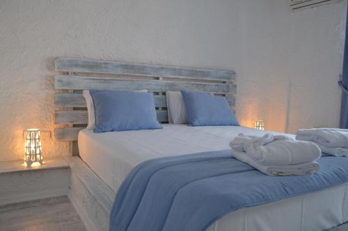 a bedroom with a bed with blue and white pillows at Thea Butik Hotel & Restaurant in Siğacık