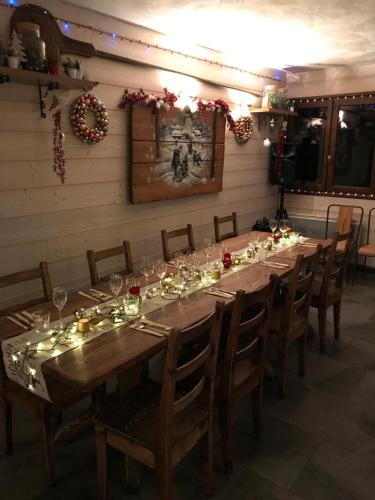 a long dining room with a long table with wine glasses at La Chanterelle - Mountain Lodge in La Côte dʼArbroz