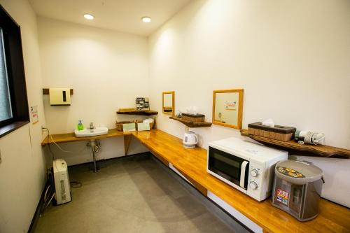 una cocina con microondas en una encimera de madera en Asian Camp Resort TAPA, en Minakami