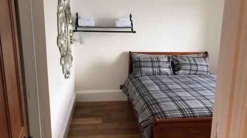 a small bedroom with a bed and a shelf at Fasgadh Rooms in Tarbert