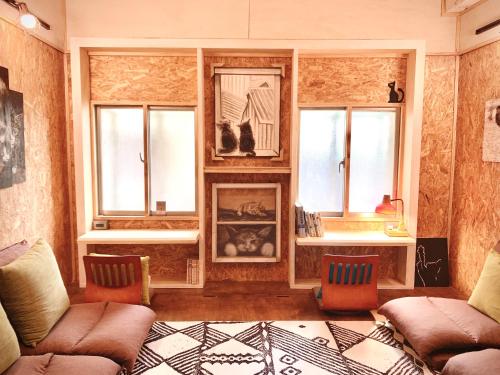 a living room with two couches and two windows at Shadow house in Tainan
