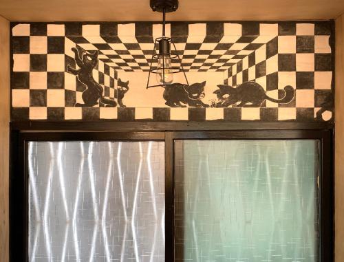 a window with two cats on a checkered wall at Shadow house in Tainan