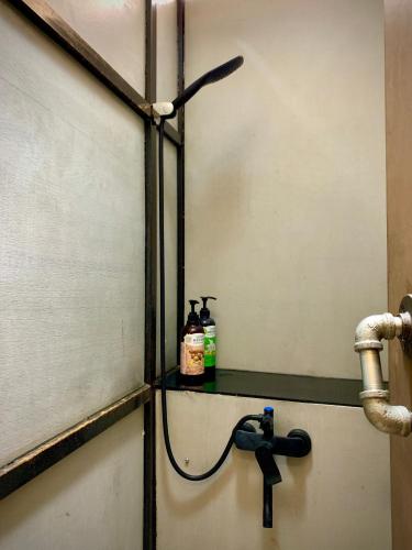 a bathroom with a sink with two bottles on a shelf at Shadow house in Tainan