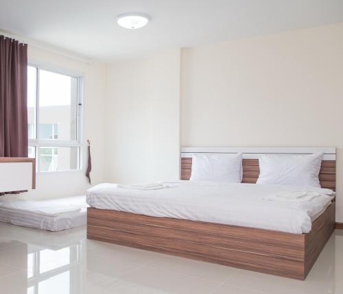 a bedroom with a large bed and a window at My Room in Ratchaburi