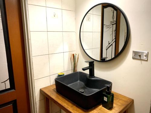 a bathroom with a black sink and a mirror at Shadow house in Tainan