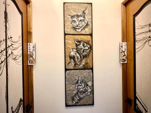 a painting of four cats hanging on a wall at Shadow house in Tainan