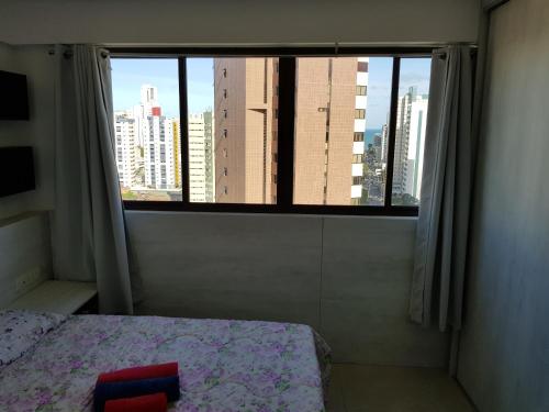 1 dormitorio con vistas a la ciudad desde una ventana en Flat Decorado luxo em Boa Viagem junto ao Shopping, en Recife