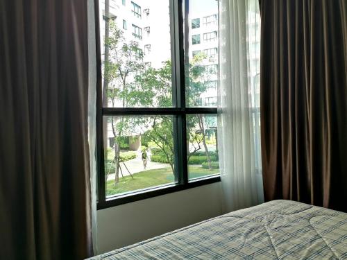 a bedroom with a window looking out at a park at 2 Floor - Centrio Condominium near Central Shopping Mall and Phuket Old town in Phuket