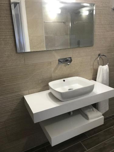 a bathroom with a white sink and a mirror at Regina Apartments in Lassi