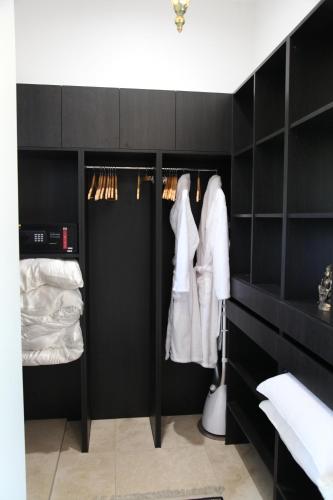 um armário preto com armários pretos e roupas brancas em Jodha Bai Retreat em Terranora