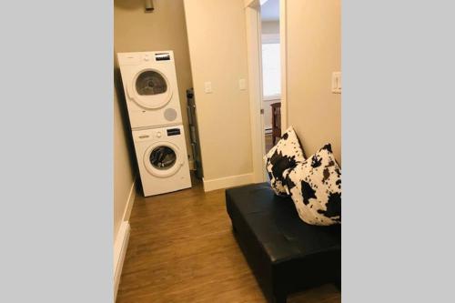a living room with a couch and a washing machine at A Cozy Family get away suite in South Nanaimo in Nanaimo