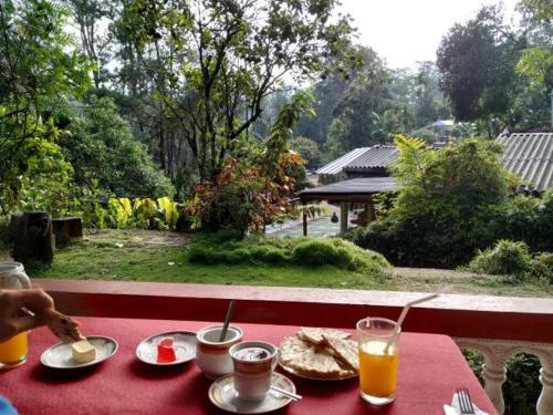 una mesa con un mantel rojo con comida y bebida en Misty Mount Homestay, en Ella