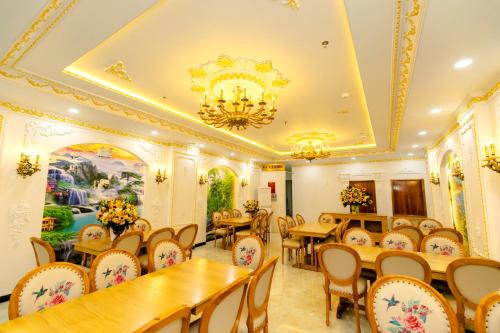 a restaurant with tables and chairs and a chandelier at HaTa Hotel in Quy Nhon