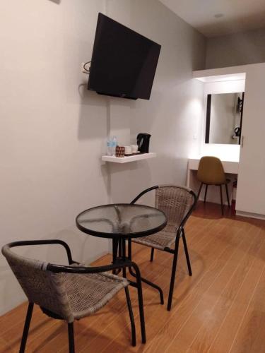 a table and two chairs and a television in a room at Tropical Fun Ta Sea Rentals in Siquijor