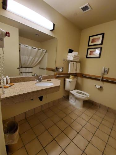 a bathroom with a toilet and a sink and a mirror at Country Inn & Suites by Radisson, Bend, OR in Bend