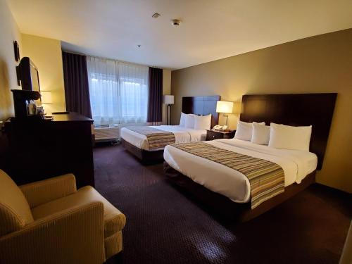 a hotel room with two beds and a couch at Country Inn & Suites by Radisson, Bend, OR in Bend