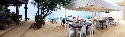 a restaurant with tables and chairs on the beach at Tropical Fun Ta Sea Rentals in Siquijor