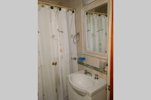 W łazience znajduje się umywalka, toaleta i lustro. w obiekcie Abasto House w mieście Rosario