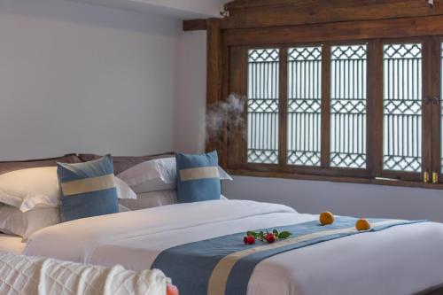 a bedroom with two beds with flowers on the fronts at Artistic-Suite in Lijiang