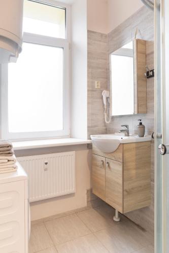 a bathroom with a sink and a mirror at Sweet Apartments in Šiauliai