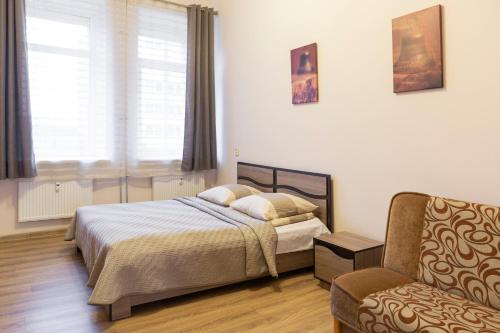 a bedroom with a bed and a chair at Sweet Apartments in Šiauliai