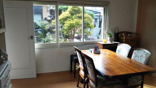 a dining room with a table and chairs and a window at 町中ステイ 宗ハウス in Nachikatsuura