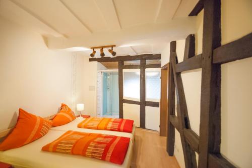 two beds in a room with orange pillows at Alte Weinstube Burg Eltz in Treis-Karden