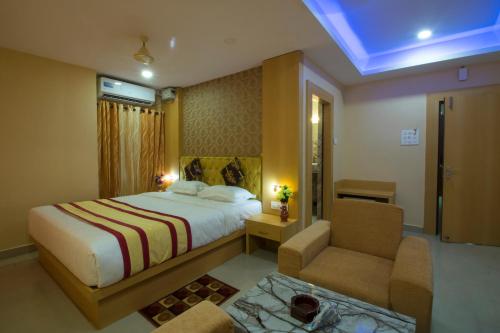 a hotel room with a bed and a chair at CITY VIEW in Port Blair