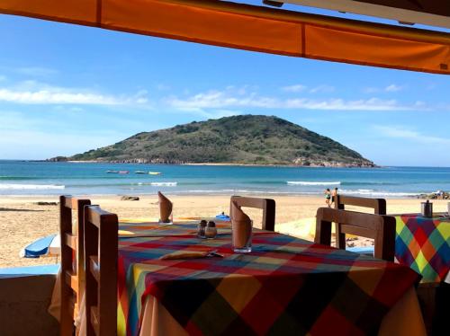 a table on a beach with a view of the ocean at Playa Suites Mazatlán in Mazatlán