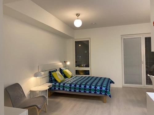ein Schlafzimmer mit einem Bett mit gelben Kissen darauf in der Unterkunft QnQ studio apartment in Helsinki