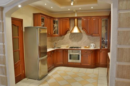 a kitchen with wooden cabinets and a stainless steel refrigerator at Apartment Nevskaya Classica in Saint Petersburg