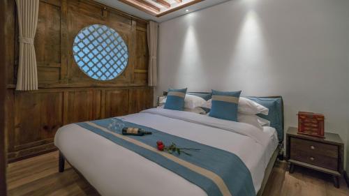 a bedroom with a large bed with a window at Artistic-Suite in Lijiang